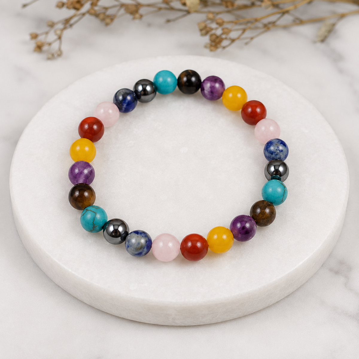 7 Chakra natural crystal stone bracelet displayed on a white marble plate by Divyazone