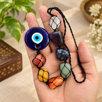 7 Chakra Evil Eye Hanging displayed in hand showing colorful stones, black cord and blue Nazar 