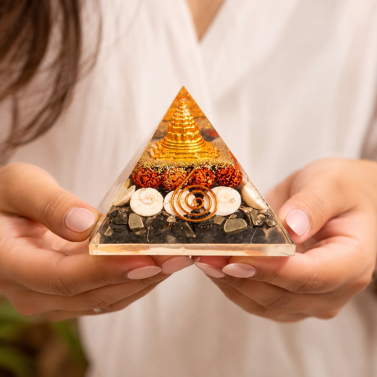 Lakshmi Yantra Orgonite Pyramid held by hand showing product details and natural elements