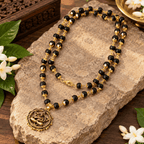 Close-up of natural Karungali Mala with gold-plated beads and Hanuman Kavach pendant