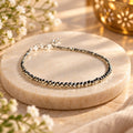 Natural raw Pyrite anklet displayed on a stone platform with premium spiritual styling