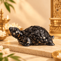 Black Pyrite Tortoise Vastu figurine displayed on a warm cream stone surface with elegant decor